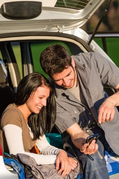 Happy couple in camping car looking at camera pictures sunset
