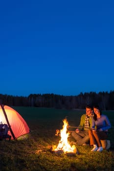 Camping night couple cook by campfire backpack in romantic countryside