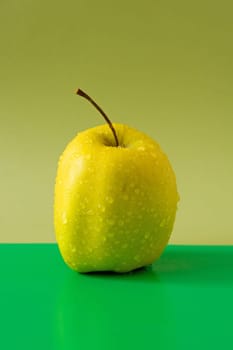 wet fresh apple isolated on green background