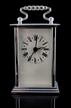 old clock on black background with reflection