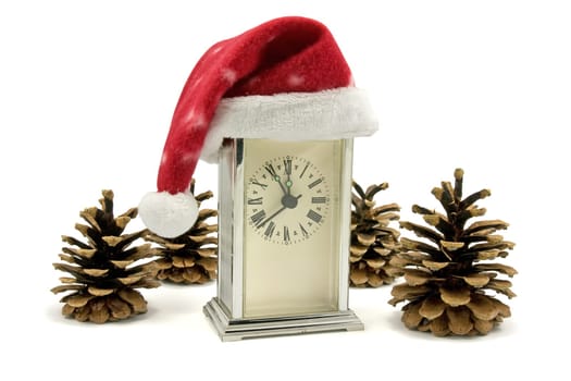 clock with Santa hat and pine cones over white