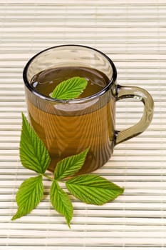 cup with tea and green leaves on the table