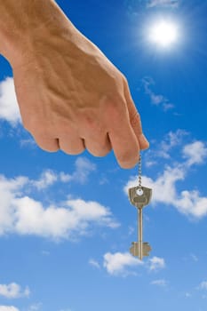 hand holding key,blue skies in the background