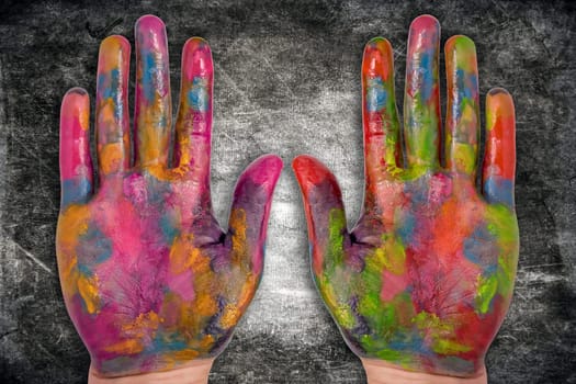 two painted human hands on dark background