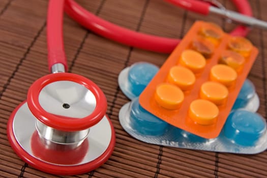 medical concept with pills and red stethoscope