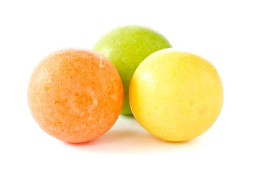 three color chewing gum balls on white background