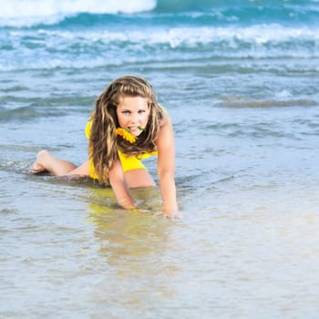Beautiful woman in yellow dress on the beach
