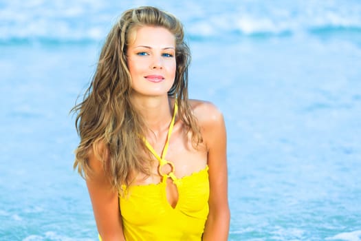 Beautiful woman in yellow dress on the beach