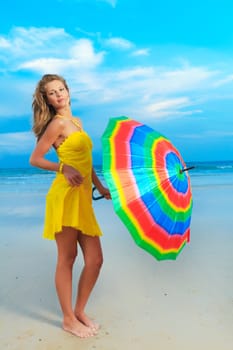 Beautiful woman in yellow dress with umbrella