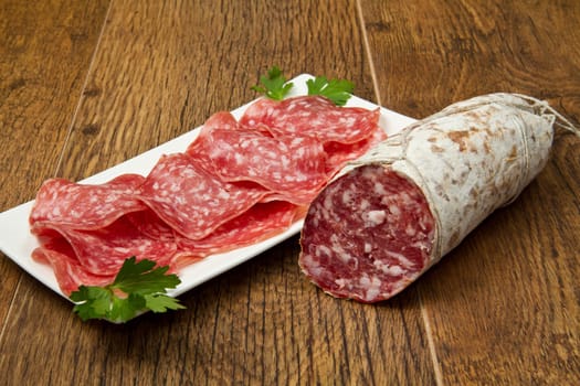 Salami sliced on wood background