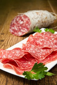 Salami sliced on wood background
