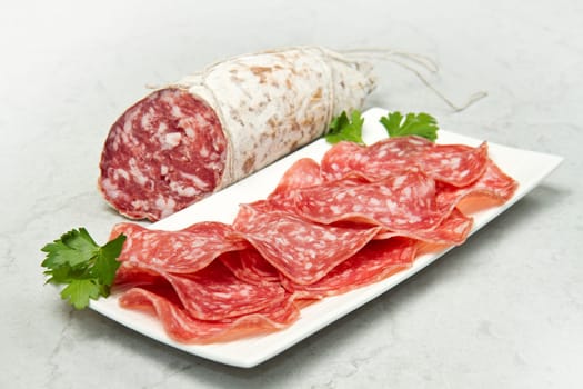 Salami sliced on marble table