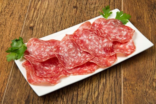 Salami sliced on wood background