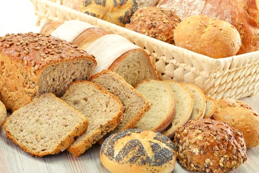Composition with bread and rolls in wicker basket isolated on white