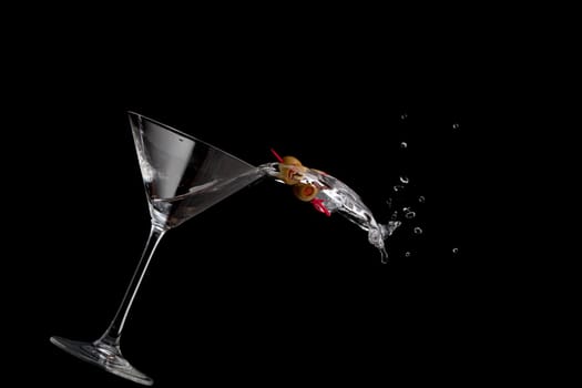 Image of a martini spilling isolated against a black background