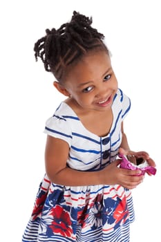 Little african american girl eating chocolate easter egg, isolated on white background