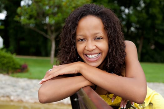 Portrait of a young beautiful african american woman sitting on a bench