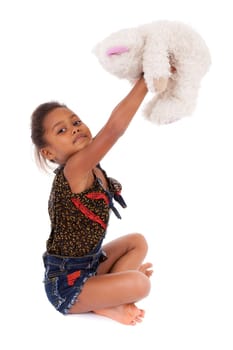 Cute little African Asian girl playing with a teddy bear,  over white background