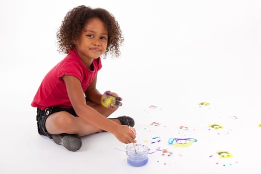 Cute Little African American girl painting on the floor