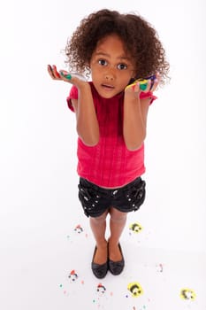 Little African Asian girl with painted hands in colorful paints