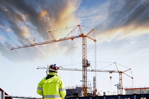 geodesy, measuring instrument, large building-site in background, sunset picture