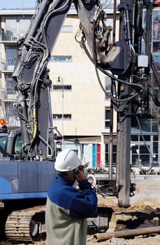 construction worker, engineer, directing heavy building machinery