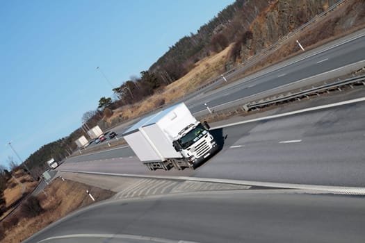 trucks driving on a scenic freeway, wide-angel perspective, elevated view