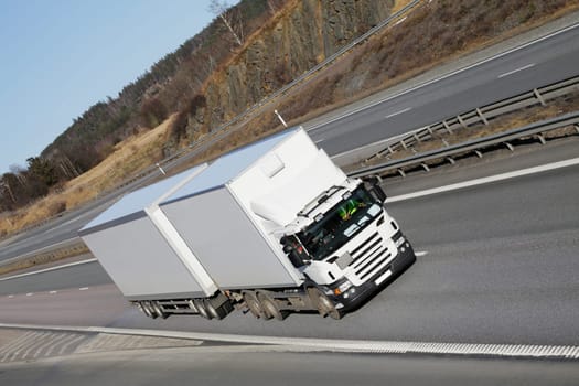 large white truck driving on freeway, elevated view