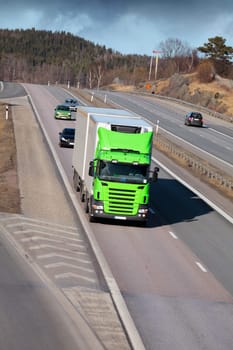 large truck driving on scenic freeway, dark clouds at horizon
