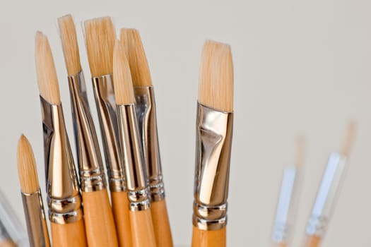 New paintbrushes in a old ceramic jar