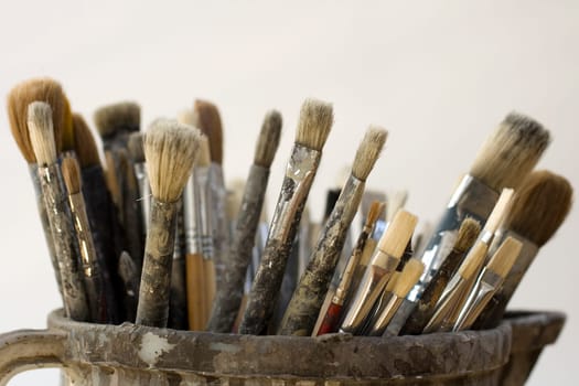 Paintbrushes inside a old jug