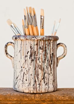 New paintbrushes in a old ceramic jar