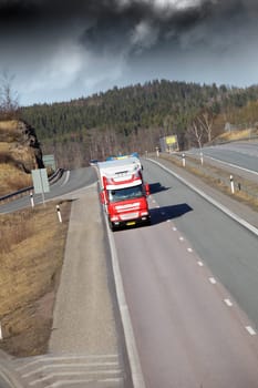 trucks driving on a scenic freeway, storm clouds at horizon