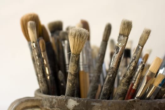 Paintbrushes inside a old jug