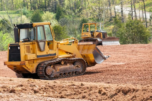 Land being levelled and cleared by yellow earth moving digger