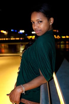 Portrait of young african american woman in city at night.