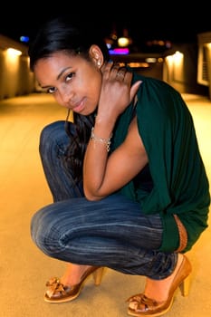 Portrait of young african american woman in city at night.