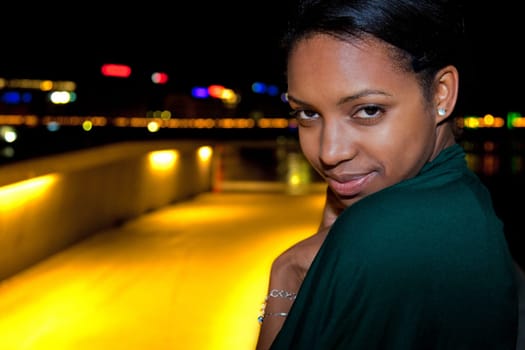 Portrait of young african american woman in city at night.