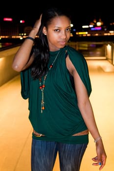 Portrait of young african american woman in city at night.