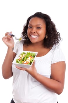 Young african american woman eating salad, isolated on white background