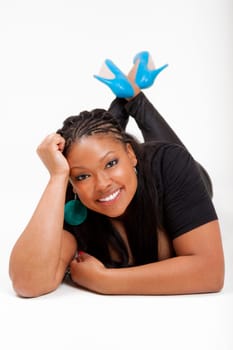 Portrait of a young beautiful black woman lied on the floor and smiling