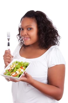 Young african american woman eating salad, isolated on white background