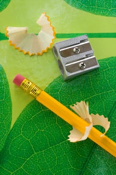 Pencil sharpneer and pencil on green texture