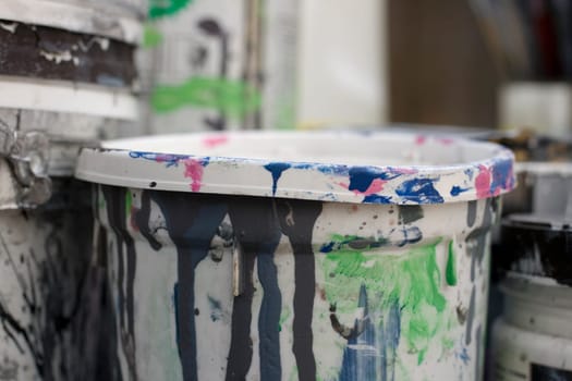 Photo of dirty plastic containers of paint