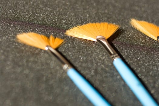 Fan shaped paintbrushees on anthracite background