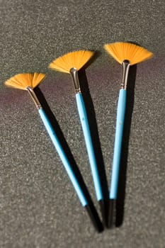Fan shaped paintbrushees on anthracite background