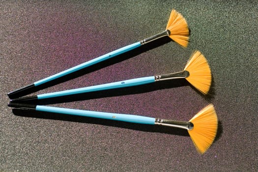 Fan shaped paintbrushees on anthracite background