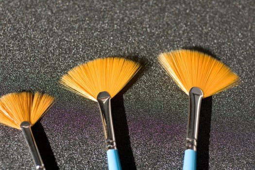 Fan shaped paintbrushees on anthracite background