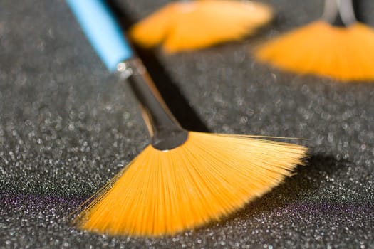 Fan shaped paintbrushees on anthracite background