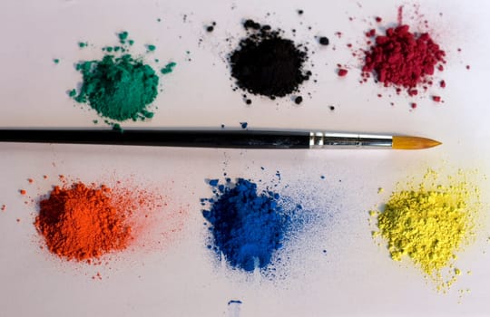 Various pigments colors and brush on a white backround